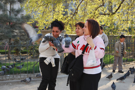 Three Unknown Women Feeding Pigeonsのeditorial素材