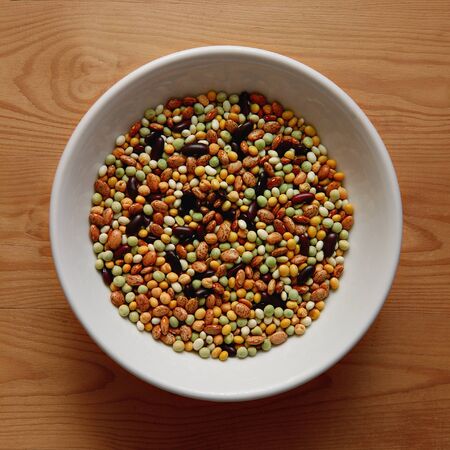 White Bowl with Various Kind of Legumes on Wood Background