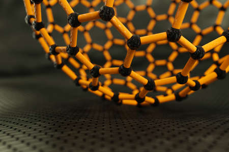3D rendering of fullerene sphere, yellow bonds, black atoms, dark backgroundの写真素材