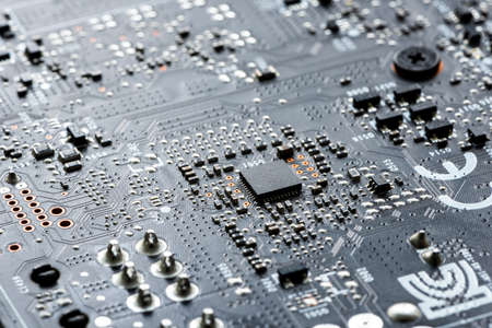 Electronic PCB printed circuit board in macro close-up with transistors circuitry and electric...