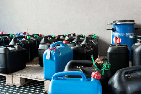 Metal and plastic barrels containing hazardous chemicals from industry, waste management concept,...