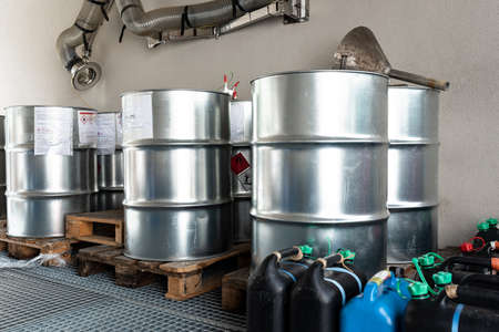 Metal and plastic barrels containing hazardous chemicals from industry, waste management concept,...