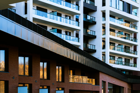 Contemporary Residential Buildings with Modern Balconies, Brick Facades, and Reflections Under a Clear Skyの写真素材
