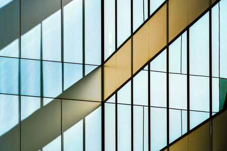 Abstract Reflection of Light and Shadows on Modern Glass Facade with Geometric Patternsの写真素材
