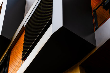 Modern Architectural Facade with Geometric Protrusions and Reflective Windows in Sunlightの写真素材