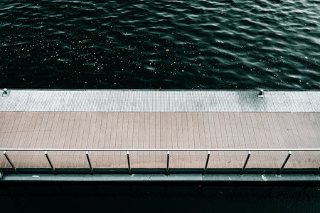 Modern Riverside Walkway Above Calm Watersの写真素材
