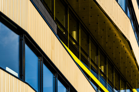 Modern Glass Building with Reflective Windows and Golden Accent Panels in Urban Setting
