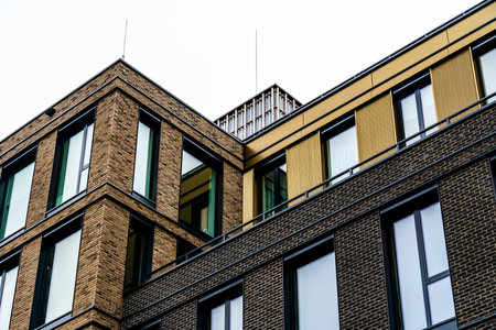 Modern Urban Building with Brick Facade, Large Windows, and Yellow Architectural Accents