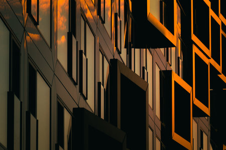 Modern residential facade with stacked orange balconies casting strong geometric shadowsの写真素材