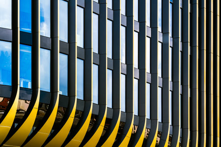 Modern Architectural Facade with Dynamic Curves and Reflective Glass Panelsの写真素材