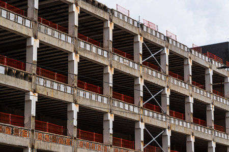 Residential development under construction with exposed concrete structure and red safety barriers