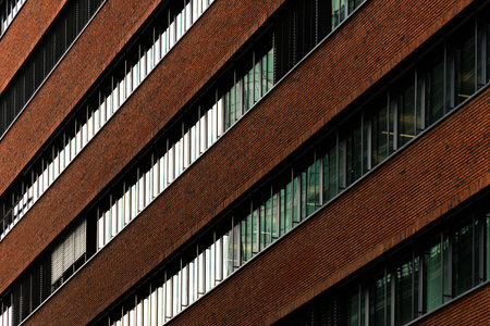 Brown facade with narrow horizontal panels and reflective glass