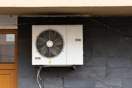 External industrial air conditioning unit with dual axial fans and exposed piping system
