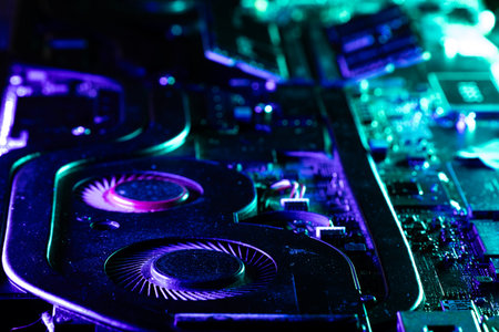 Close-up of a High-Performance GPU Cooling System with Dual Fans Under Dramatic Blue and Green...