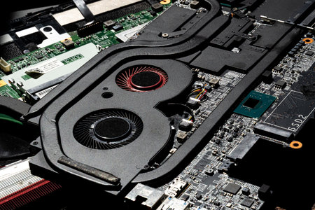 High-Resolution Close-Up of Laptop Cooling Fans, Circuit Board, and Components in Bright Technical...