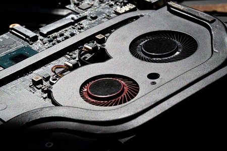 High-Resolution Close-Up of Laptop Cooling Fans, Circuit Board, and Components in Bright Technical...