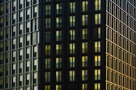 Modern residential building facade with repeating balconies and geometric grid pattern in...