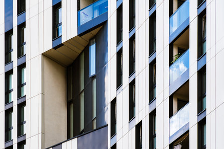 Modern office building facade with geometric white vertical panels and color tones in rhythmic...