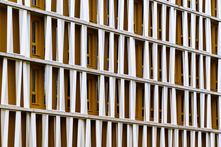 Modern office building facade with geometric white vertical panels and color tones in rhythmic...