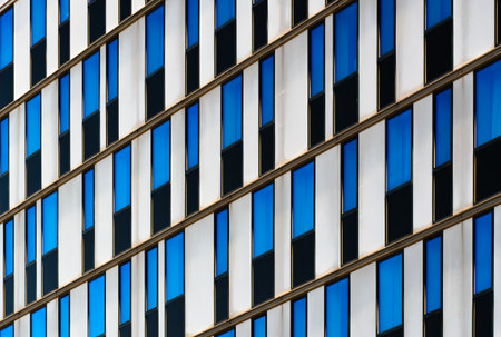 Modern office building facade with geometric white vertical panels and color tones in rhythmic...
