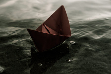 Red paper boat on the wavesの写真素材