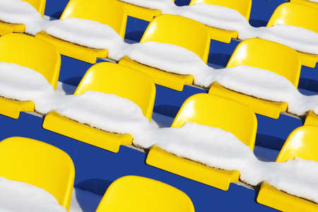 Yellow seats on tribunes of stadium under a snowの写真素材