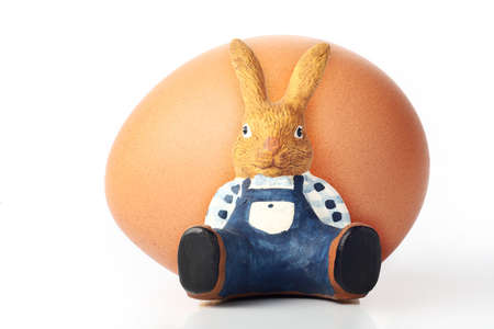 Easter bunny leaning against egg