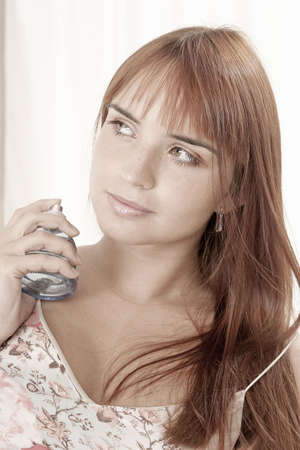 red-haired young girl, woman with  a bottle of perfume