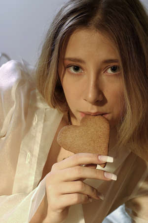blond girl, young woman with a ginger bread heartの写真素材