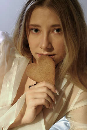 blond girl, young woman with a ginger bread heartの写真素材