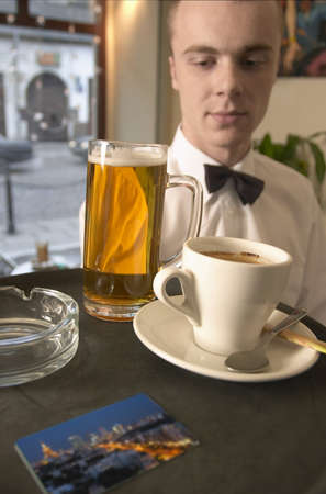 waiter serving beer and coffe in coffe bar. close - upの写真素材