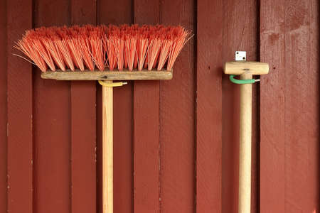 wooden sweeping brush with red bristles, on boardsの写真素材