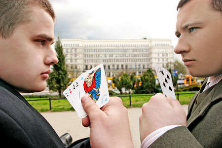 two men playing cards on a street- commercial buildings in the backgroundのeditorial素材