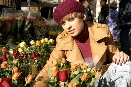 Fashion friendly smiling girl portrait outdoors buying roses.の写真素材