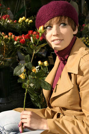 Fashion friendly smiling girl portrait outdoors buying roses.の写真素材