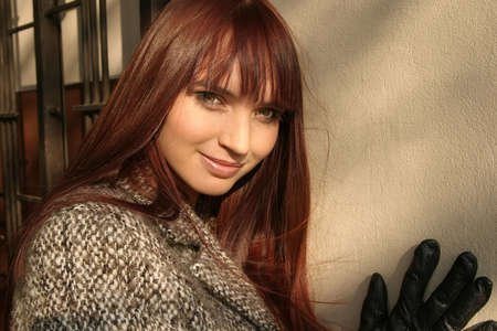 Beautiful girl standing at a wall, romantic look and smiling.の写真素材