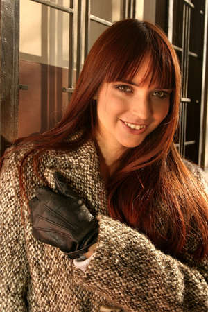 Beautiful girl standing at a wall, romantic look and smiling.の写真素材