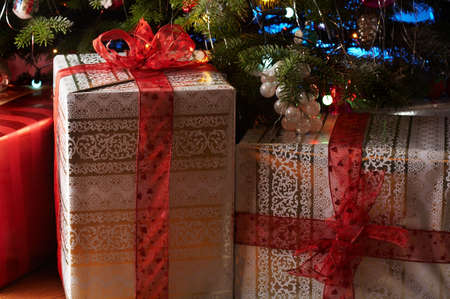 Two christmas gifts under the christmas tree with a red ribbon.の写真素材