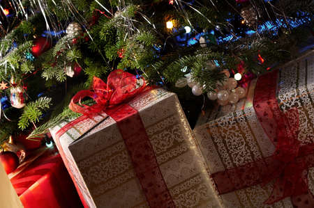 Two christmas gifts under the christmas tree with a red ribbon.の写真素材