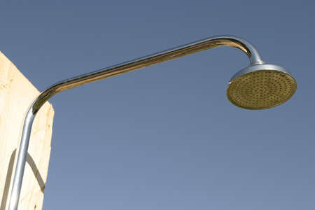 A metal shower head with clear blue sky in a background の写真素材