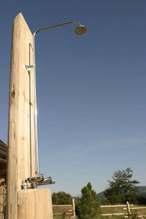 A metal shower on a camping outdoor with clear blue sky in a background の写真素材