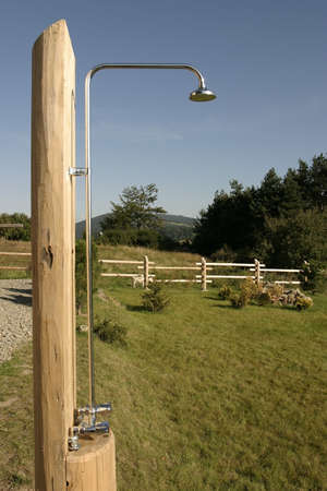 A metal shower on a camping outdoor with clear blue sky in a background の写真素材