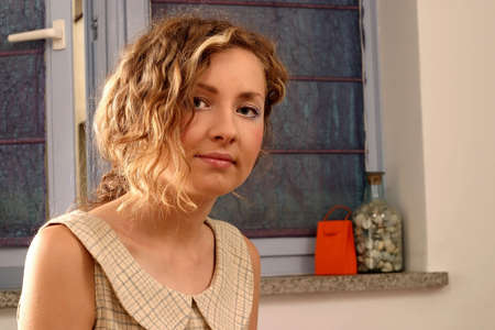 Young beautiful blonde woman with curly hair and romantic look.の写真素材