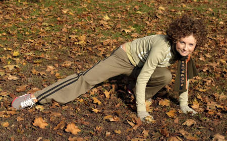 A young woman with a scarf stretching in a  park after a long run.の写真素材