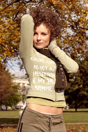 A young woman with brown curly hair in a  park with romantic look.の写真素材