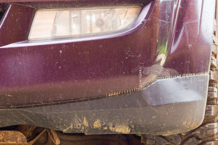 Stitched front bumper of the SUV. Stitches with nylon thread or fishing line on the repaired bumper...