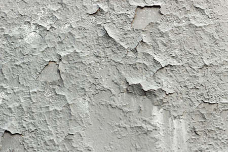 Gray cracked paint on the wall, grunge old wall texture background. Old vintage crack wall.の写真素材