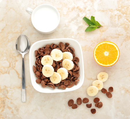 healthy Breakfast - chocolate cereal with banana and milk and oranges. top viewの写真素材