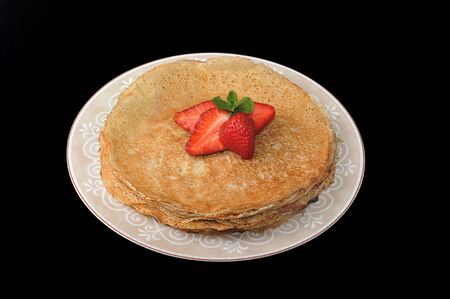 pancakes on a plate with butter on black background. top view