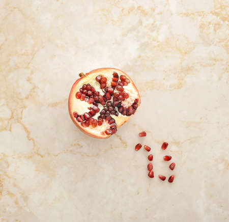 half of pomegranate on a marble background. top viewの写真素材